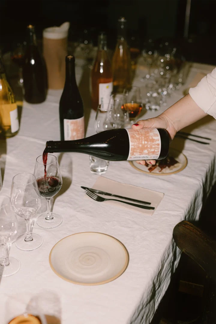 A bottle of Zinneke Wine being served at a table