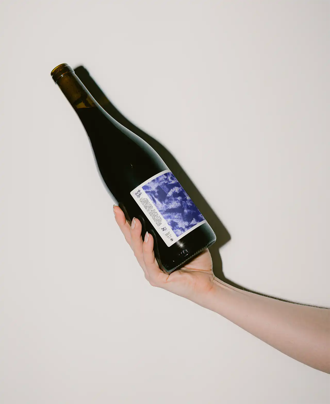 A bottle of Zinneke Wine held in the a hand of a woman